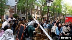 Protestocular Amsterdam Üniversitesi binalarının önündeki kanala bakan dar yola barikat kurdu.