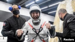 Астронавту НАСА Майку Хопкинсу помогают выбраться из капсулы SpaceX Crew Dragon Resilience после возвращения на Землю с МКС, 2 мая 2021 г. (REUTERS)